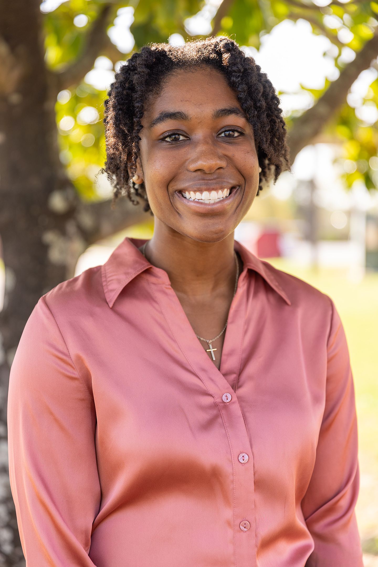 Autumn Pernell smiles into the camera with a tree behind her