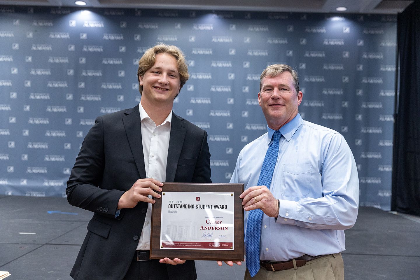 Casey Anderson holds the award and poses for a picture with dr hood