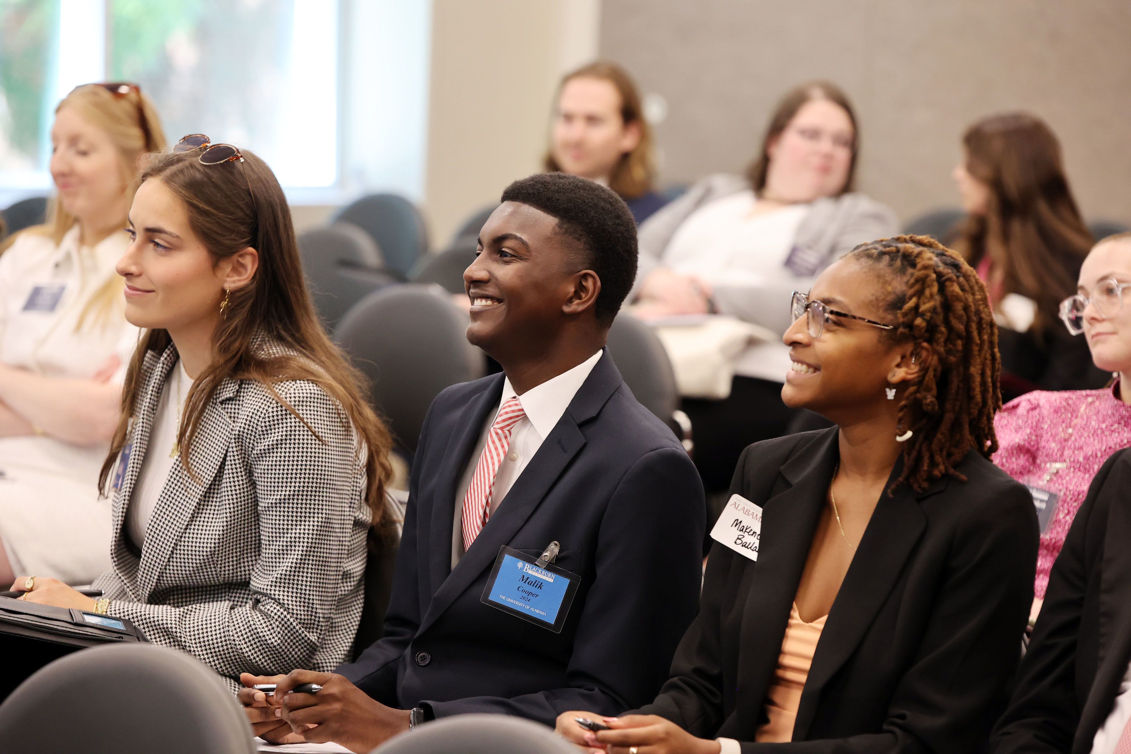 Students watching a presentation smiling