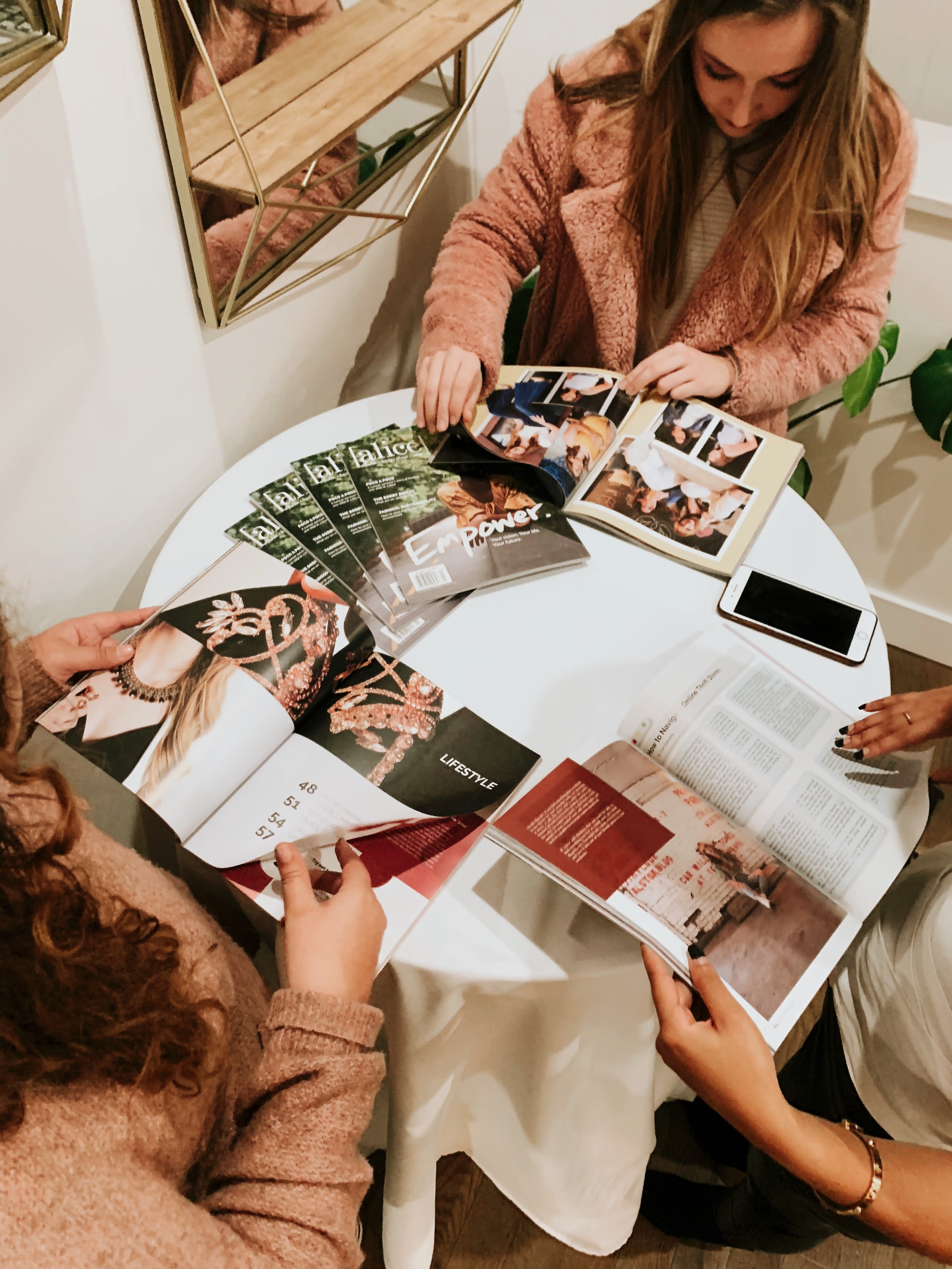 students sit at table with magazines