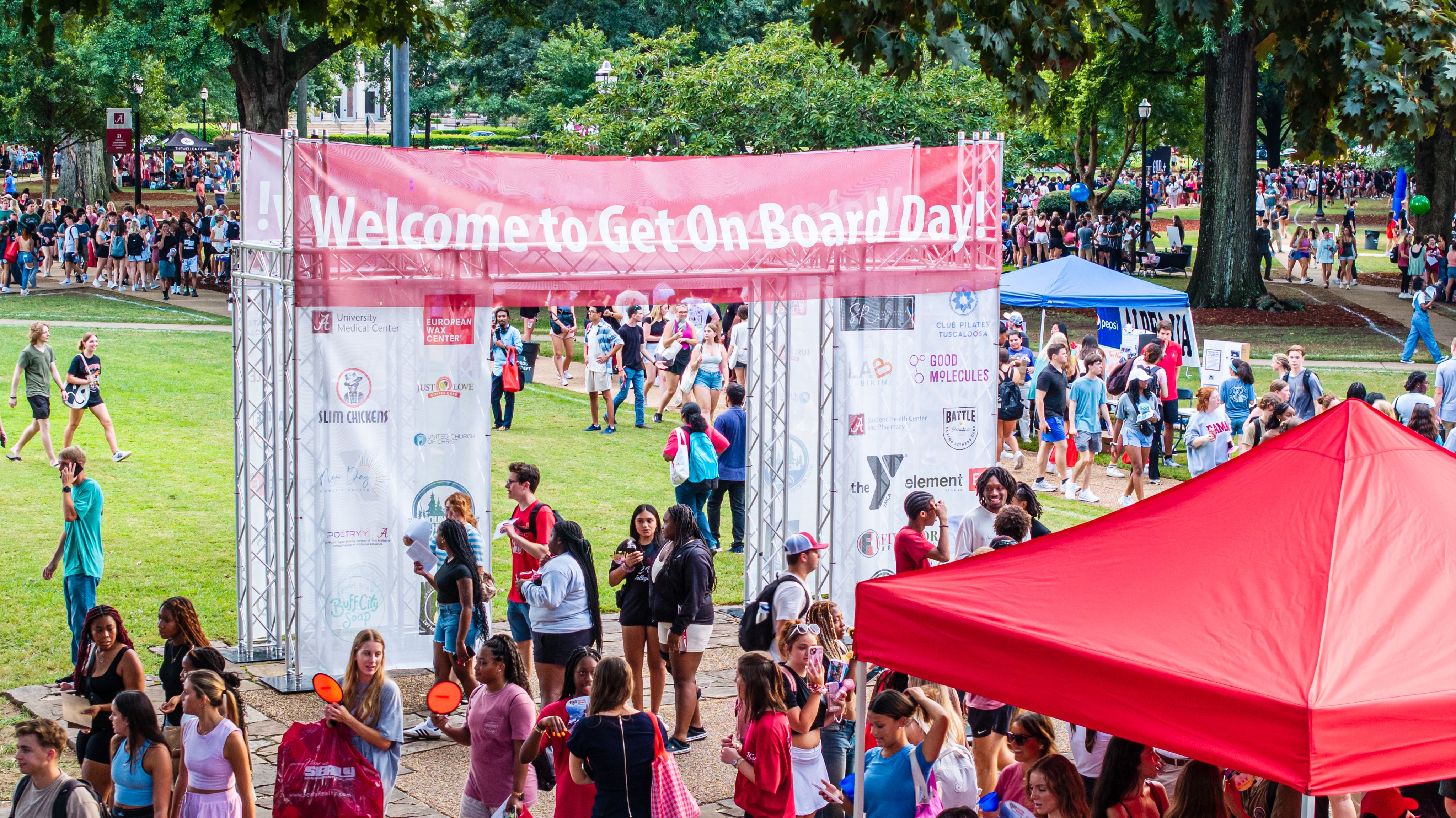 Overview show of Get on Board Day entrance sign and alot of students