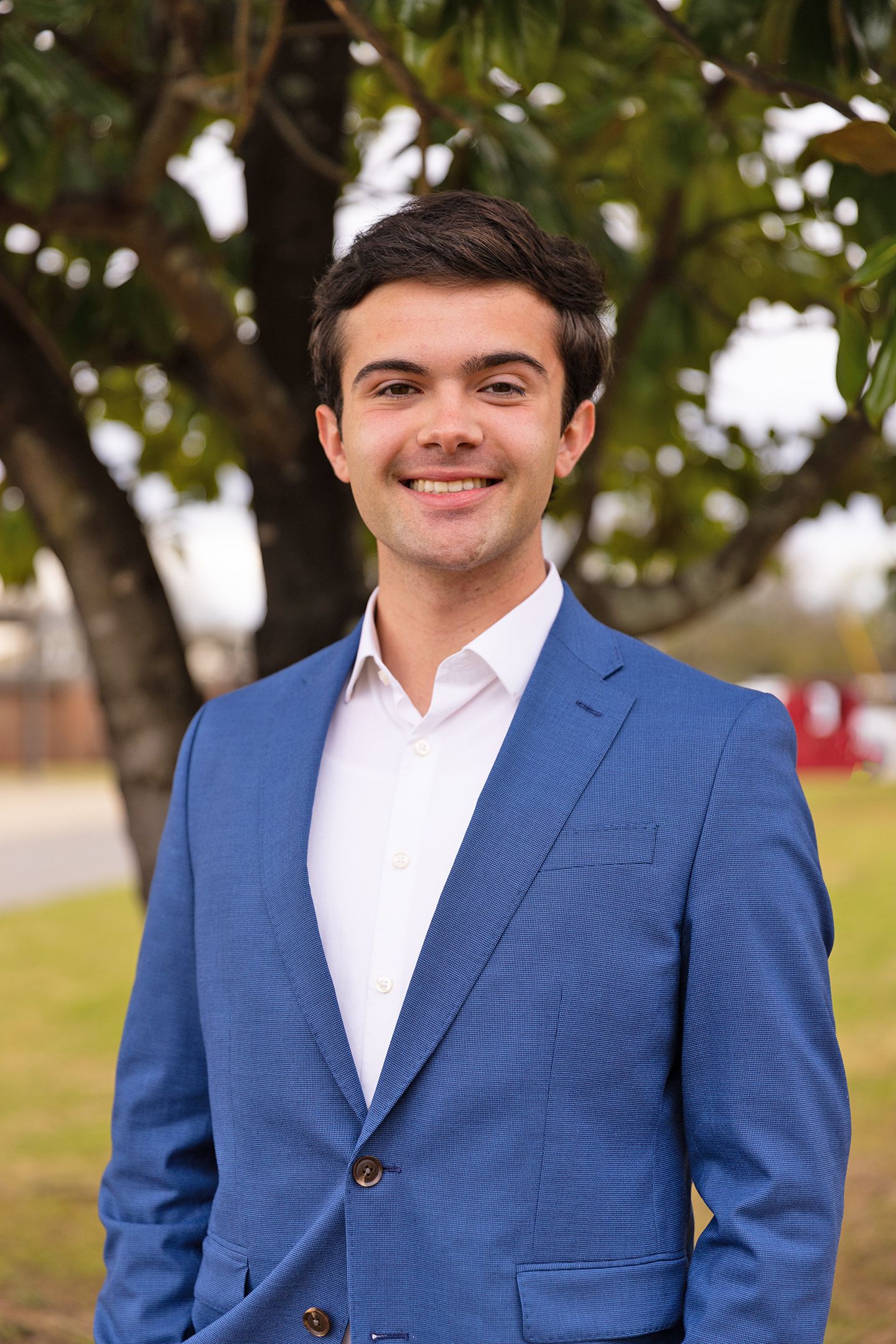 Dylan Lott into the camera with a tree in the background