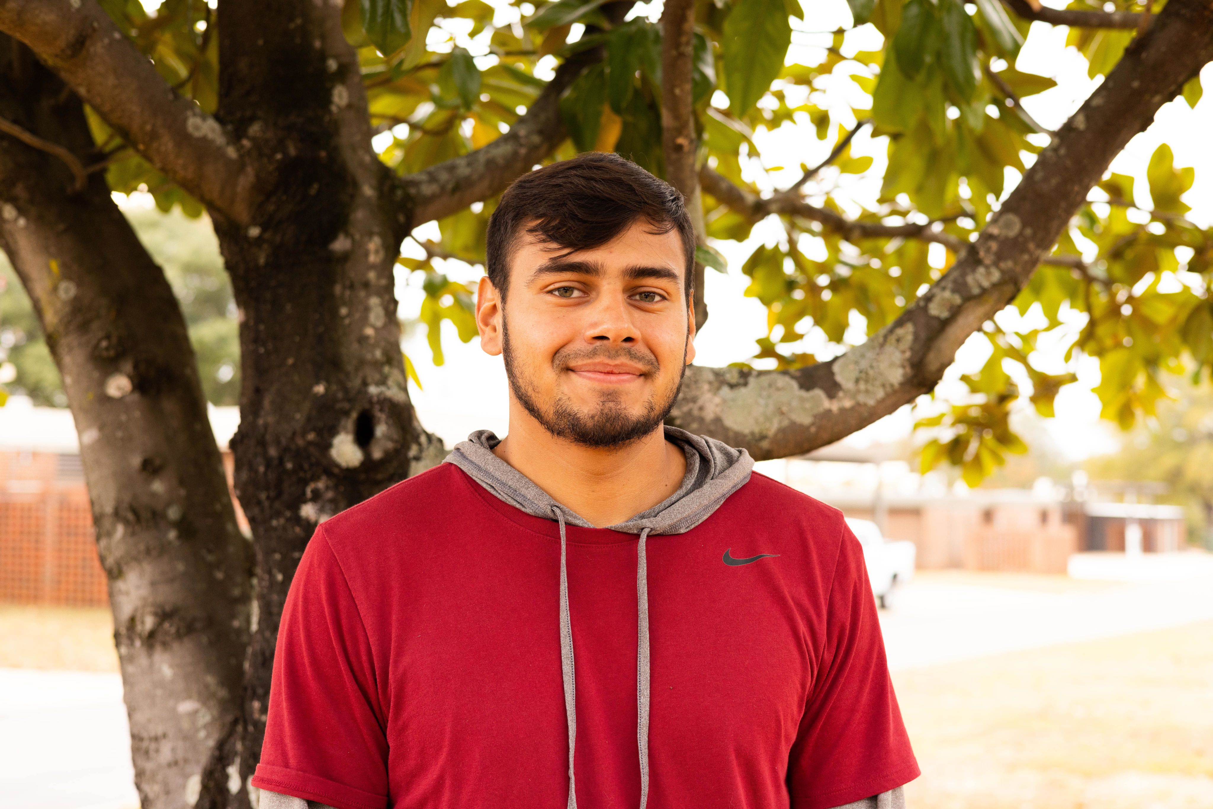 mondo smiles into the camera with a tree behind him