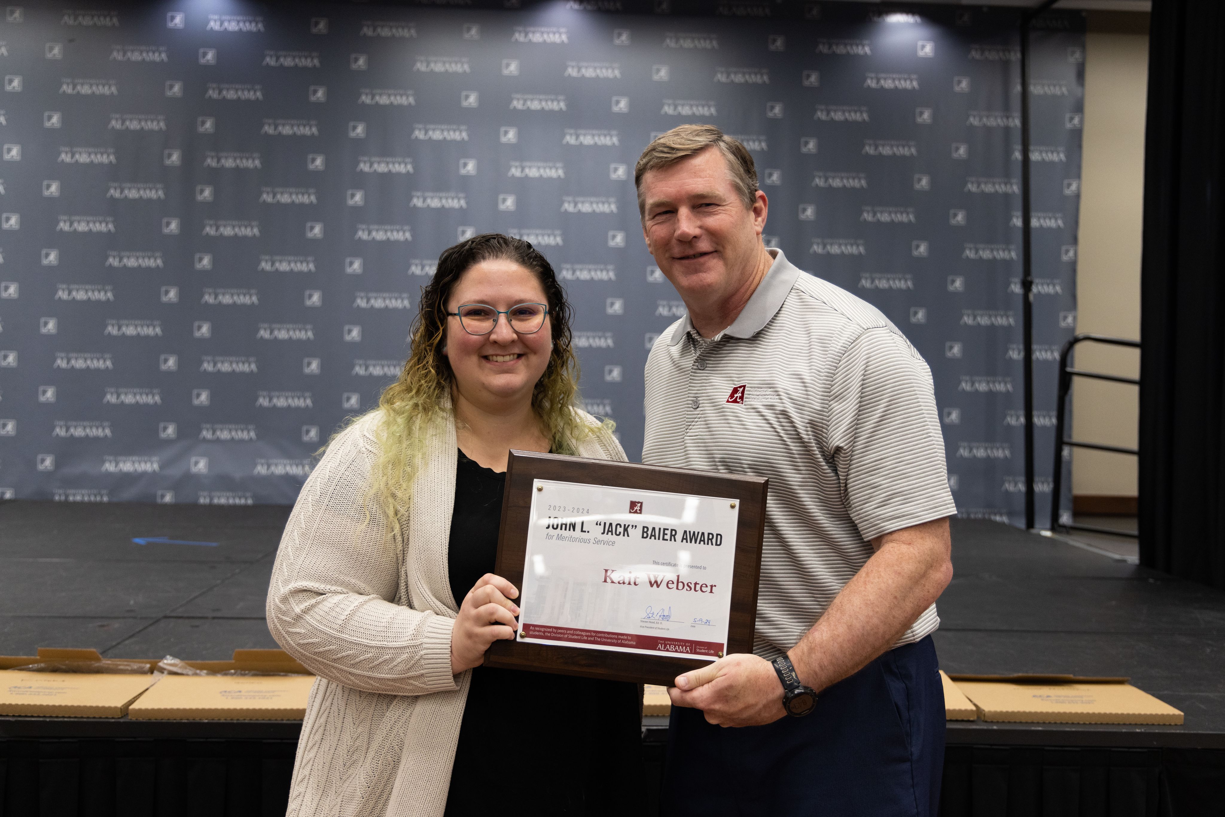 kait webster holds the award and poses for a picture with dr hood