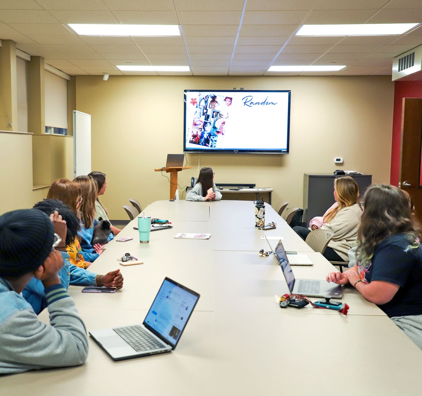 students sit in the student media newsroom to discuss projects