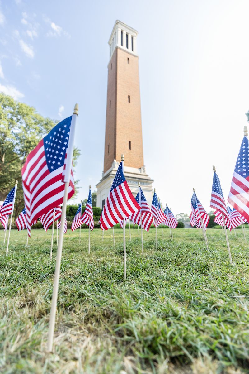 a low focal point shot of bryant denny with american flags planted in the grass