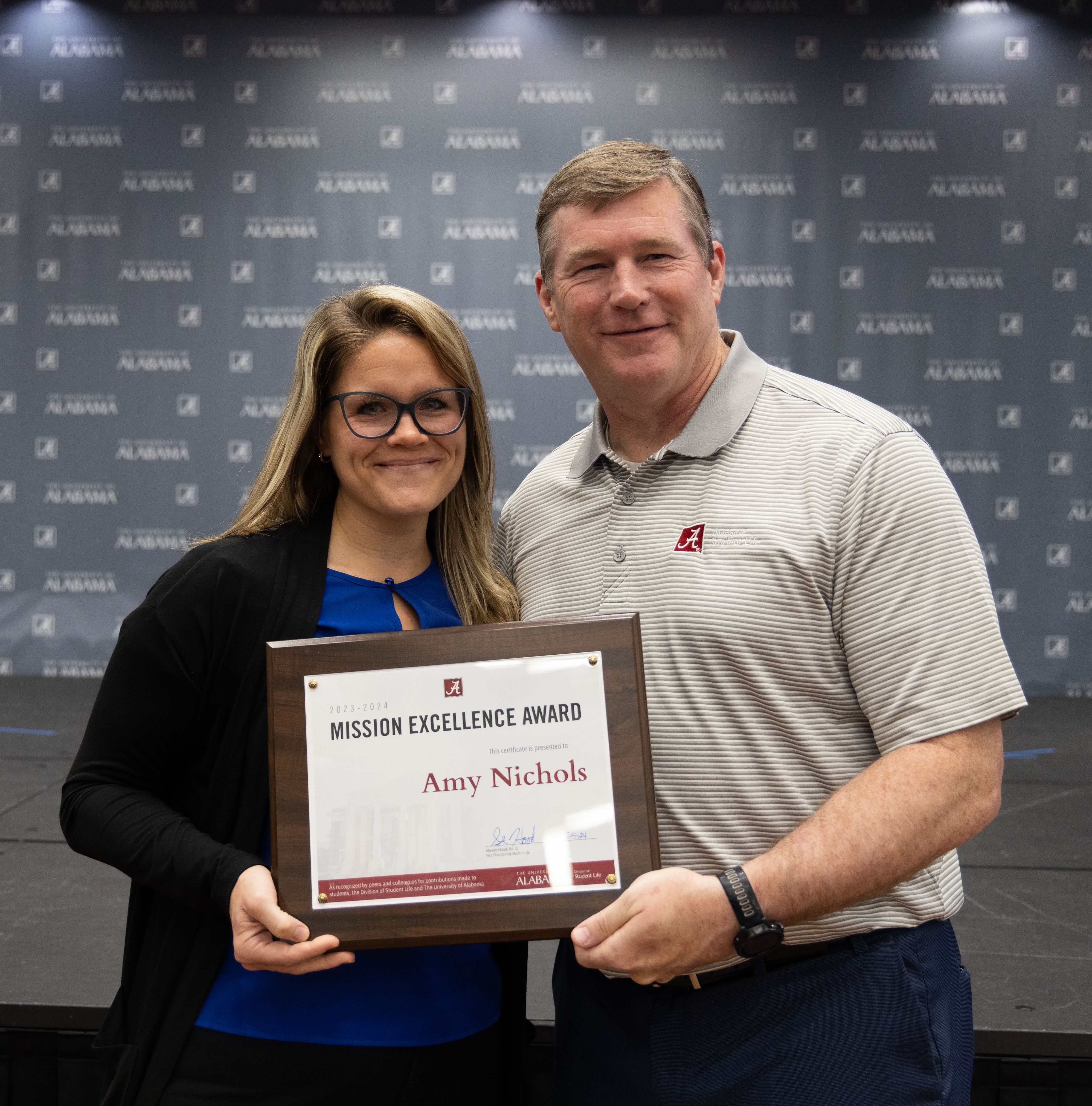 amy nichols holds the award and poses for a picture with dr hood