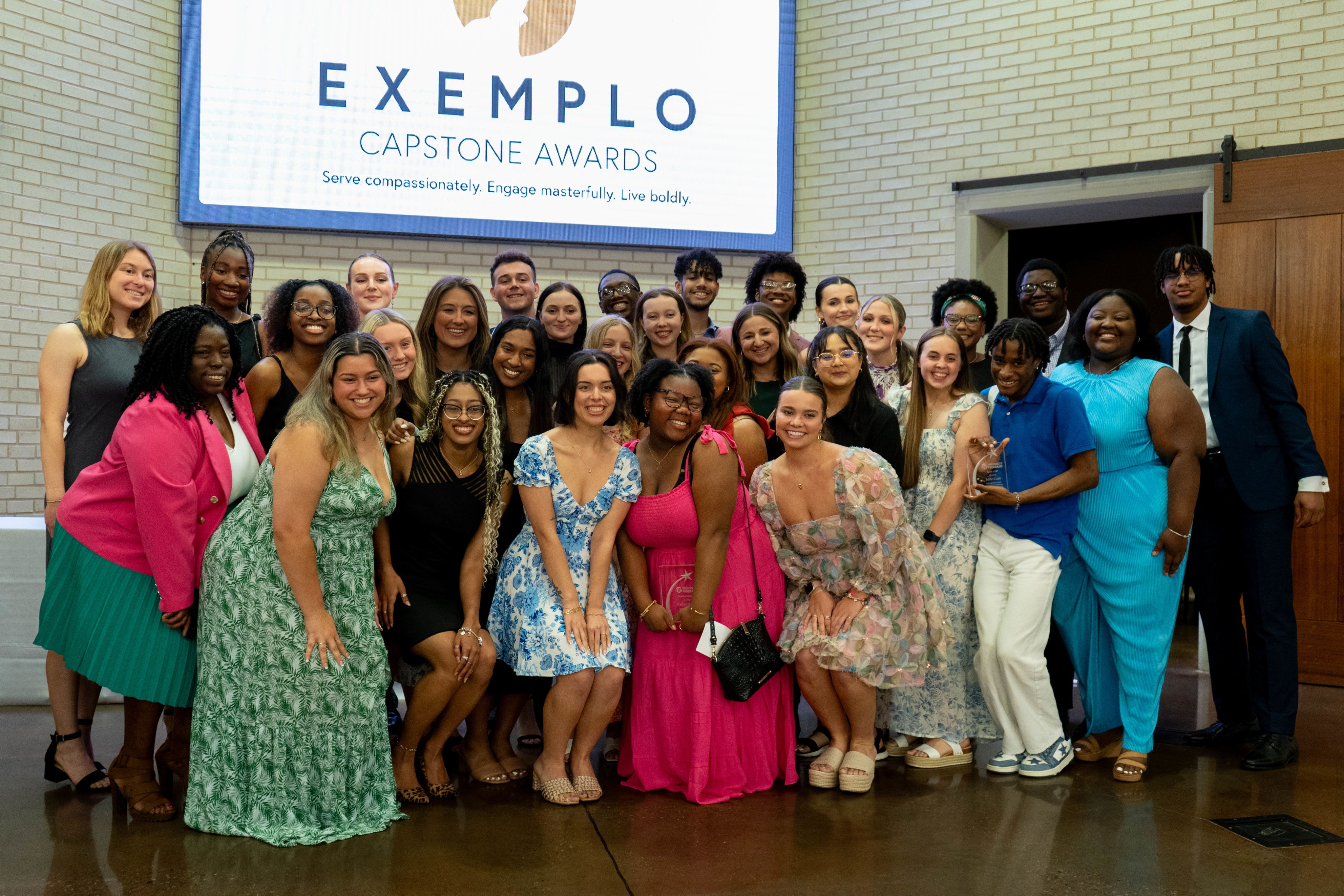 a large group of people pose for a photo at the 2023-2024 exemplo capstone awards ceremony