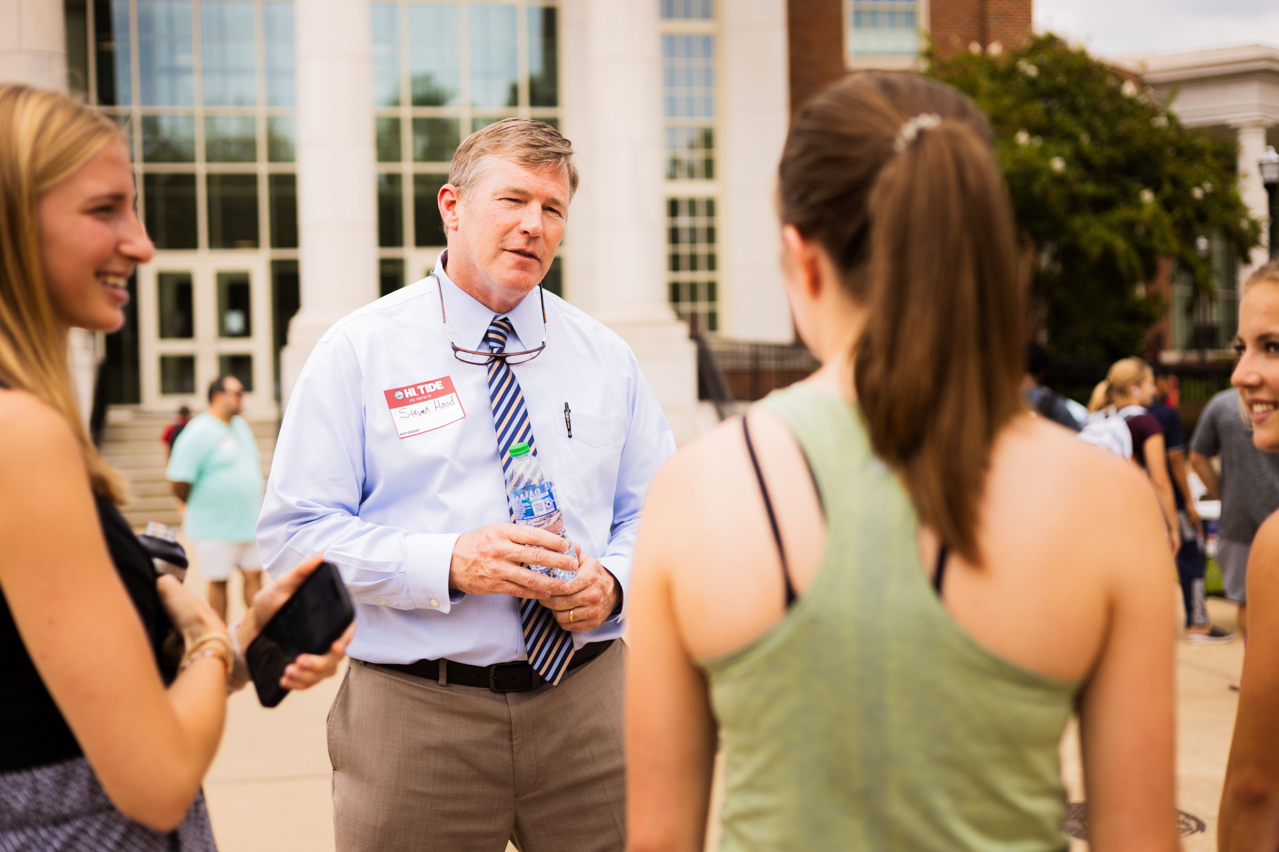 Dr. Hood holds his hands in front of him as he talks to a student