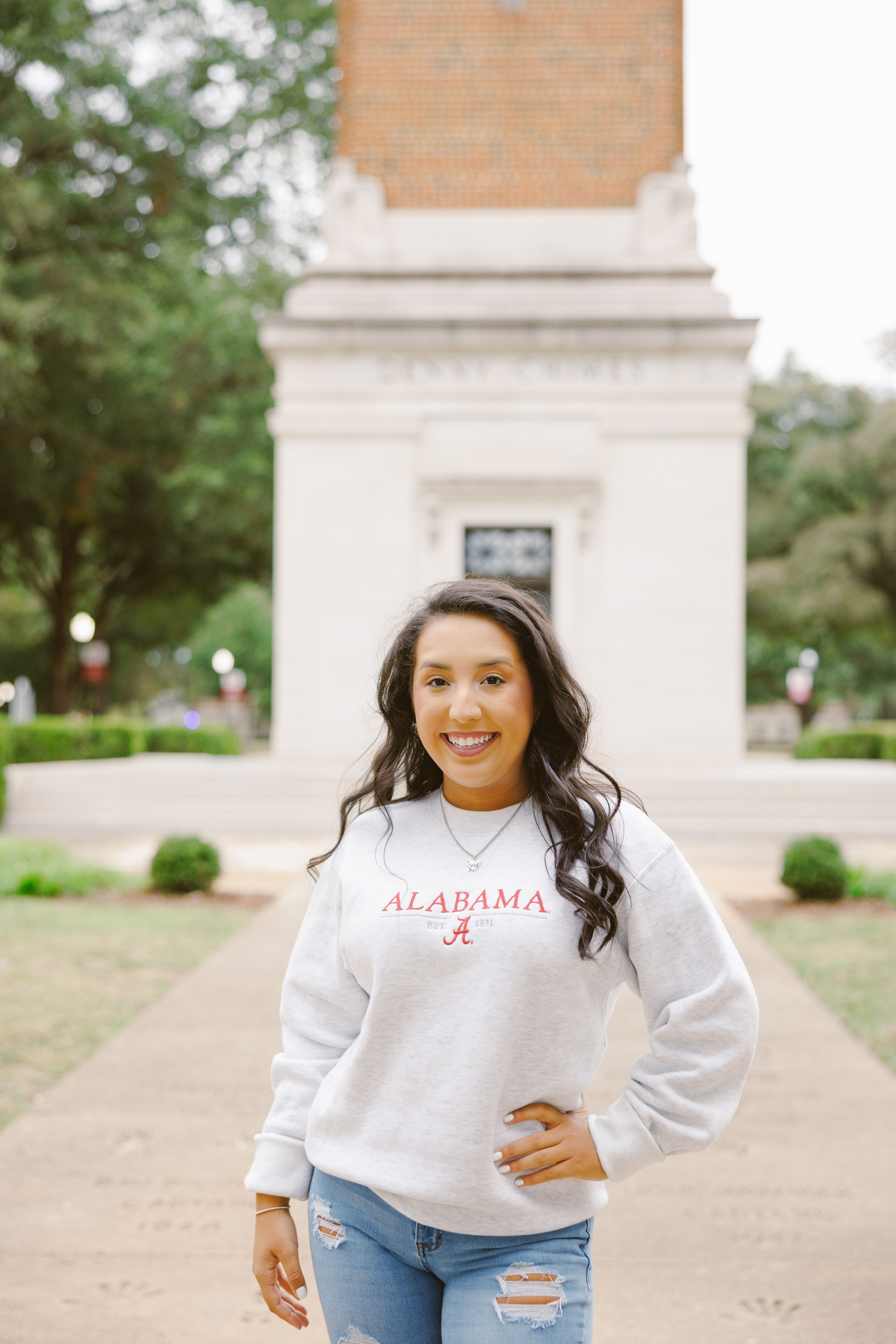 victoria poses for a photo with a hand on her hip and denny chimes behind her