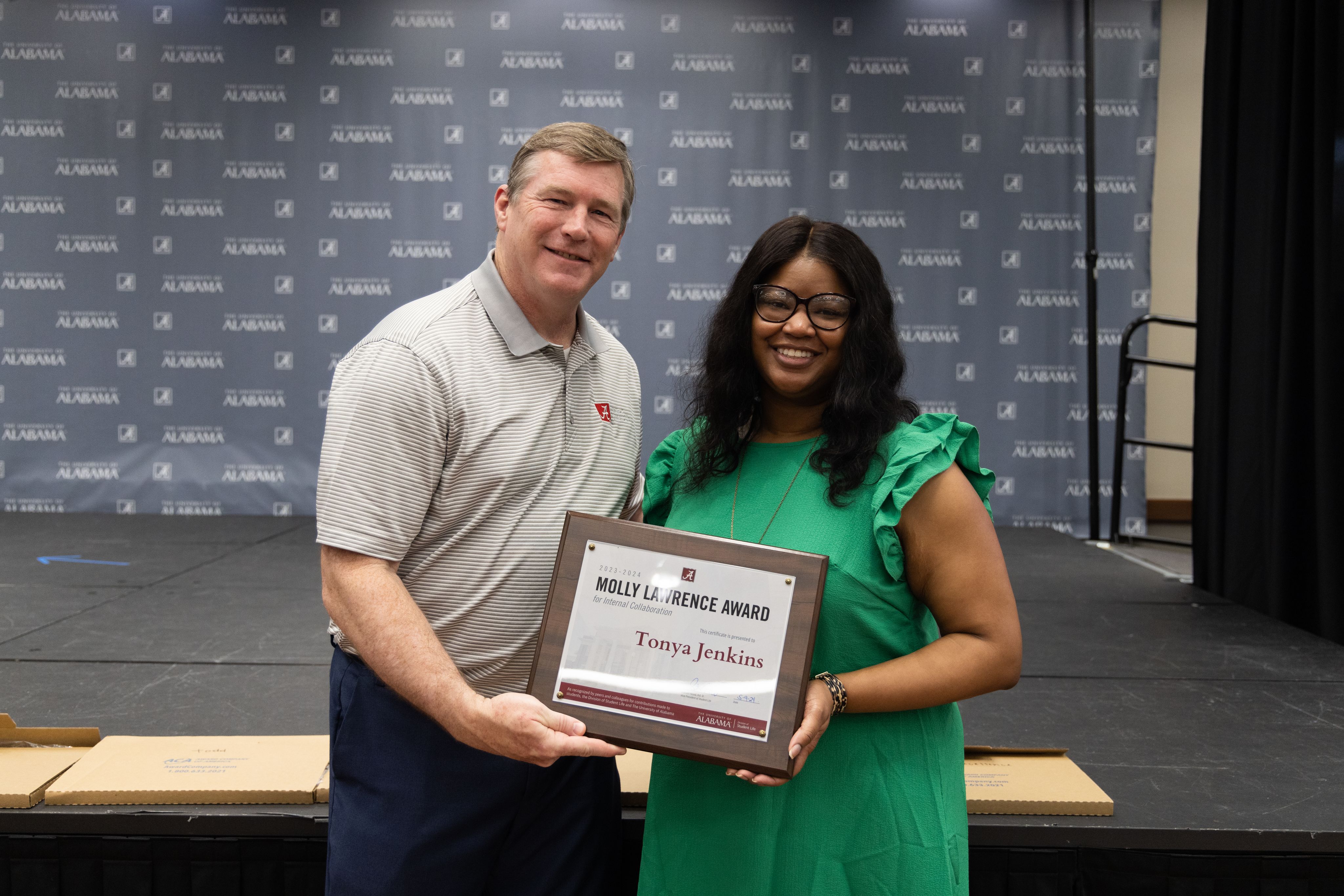 tonya jenkins holds the award and poses for a picture with dr hood