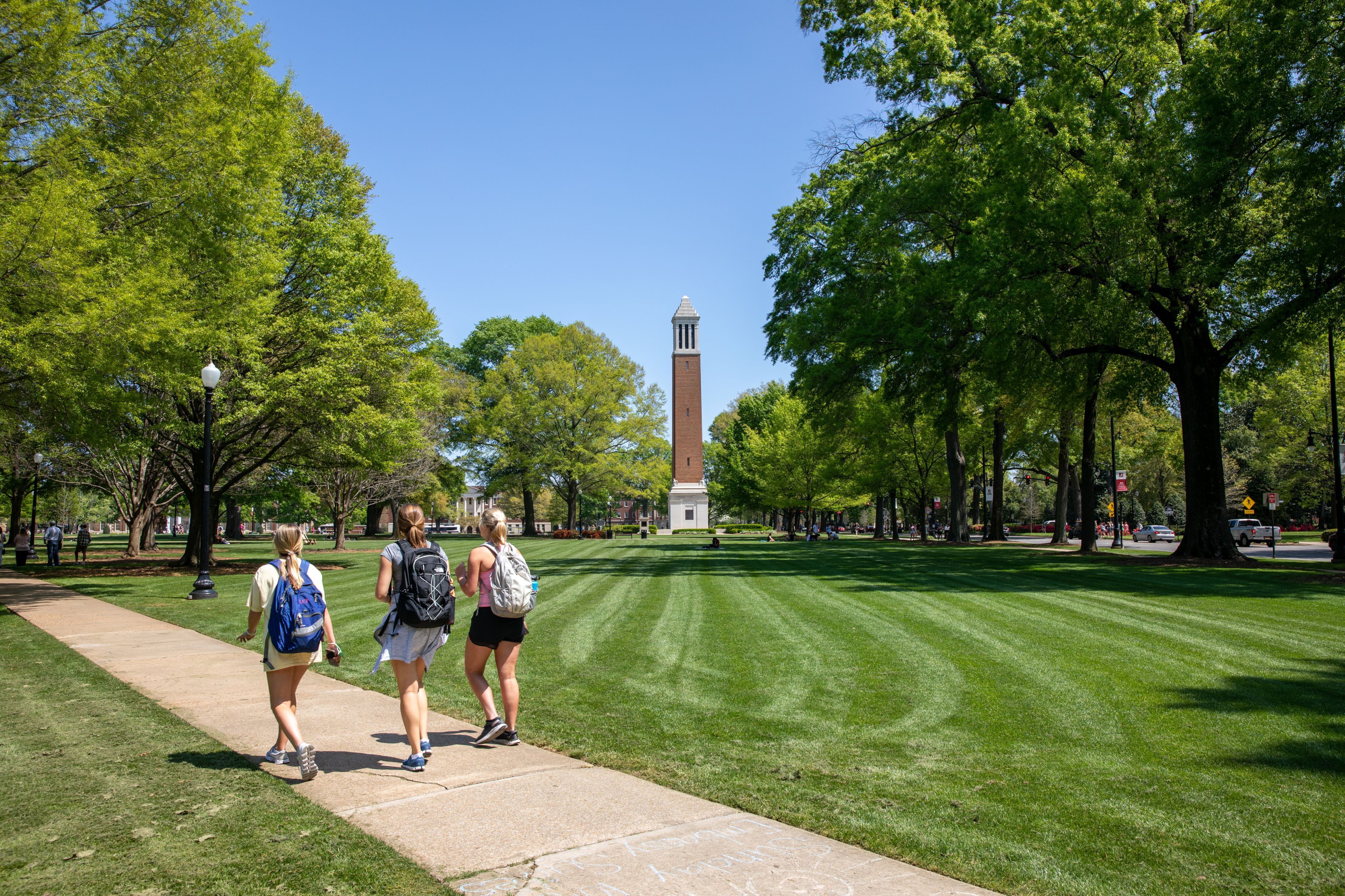 students walk through the quad with denny chimes in the background