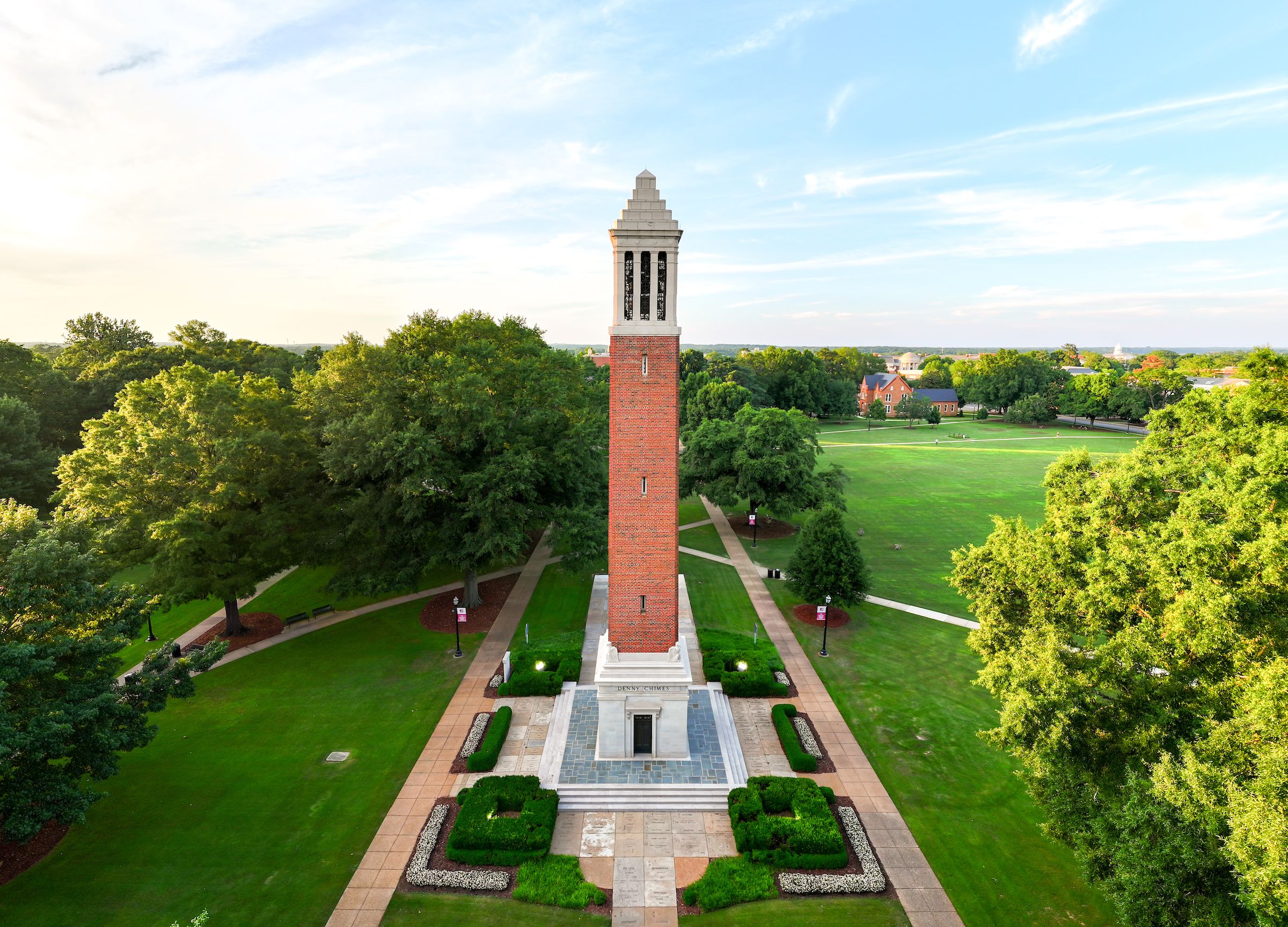 UA students relaxing in Adirondack chairs with Denny Chimes in the background