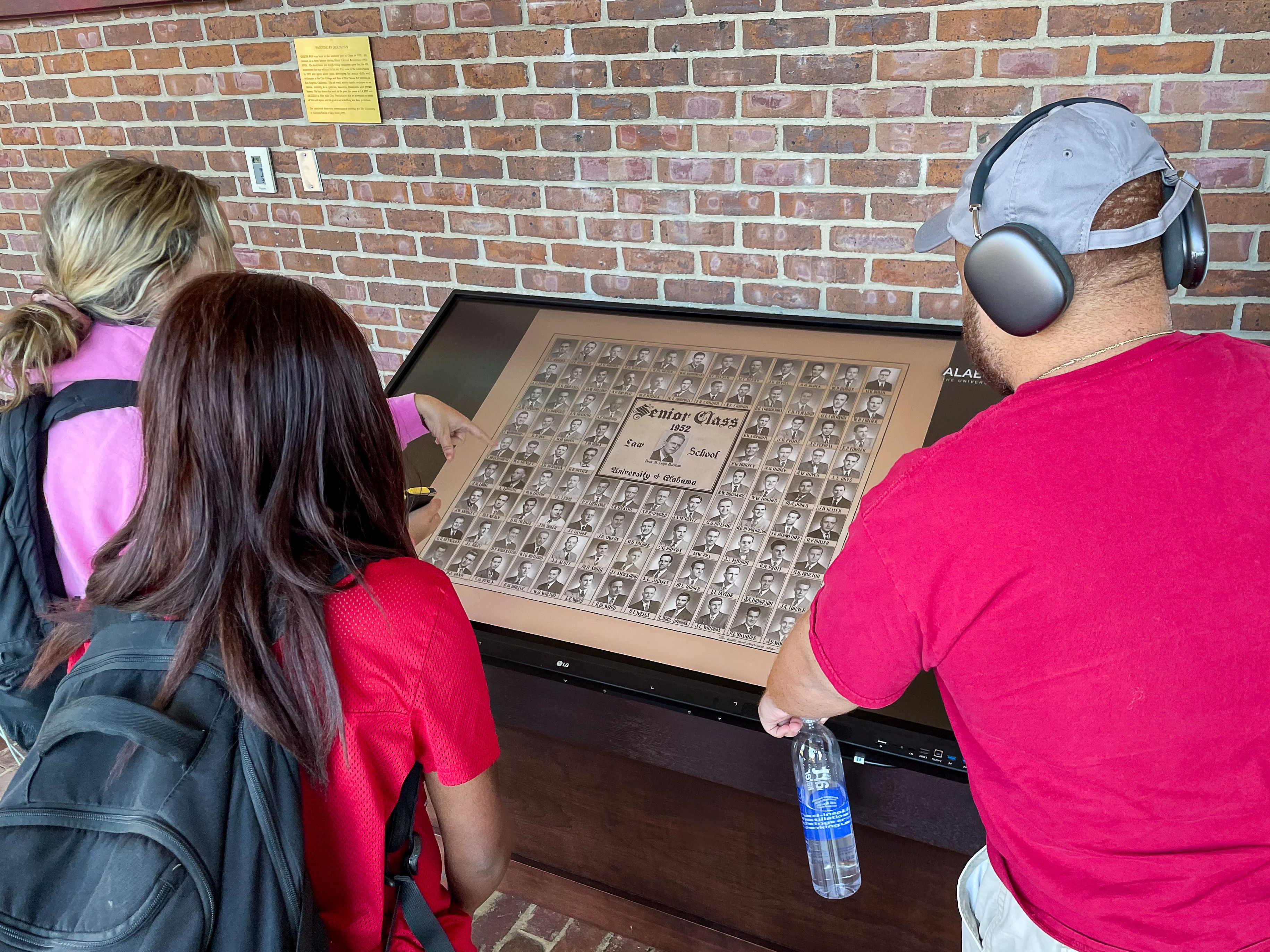 Students gathered around the new class composite display in the front foyer.