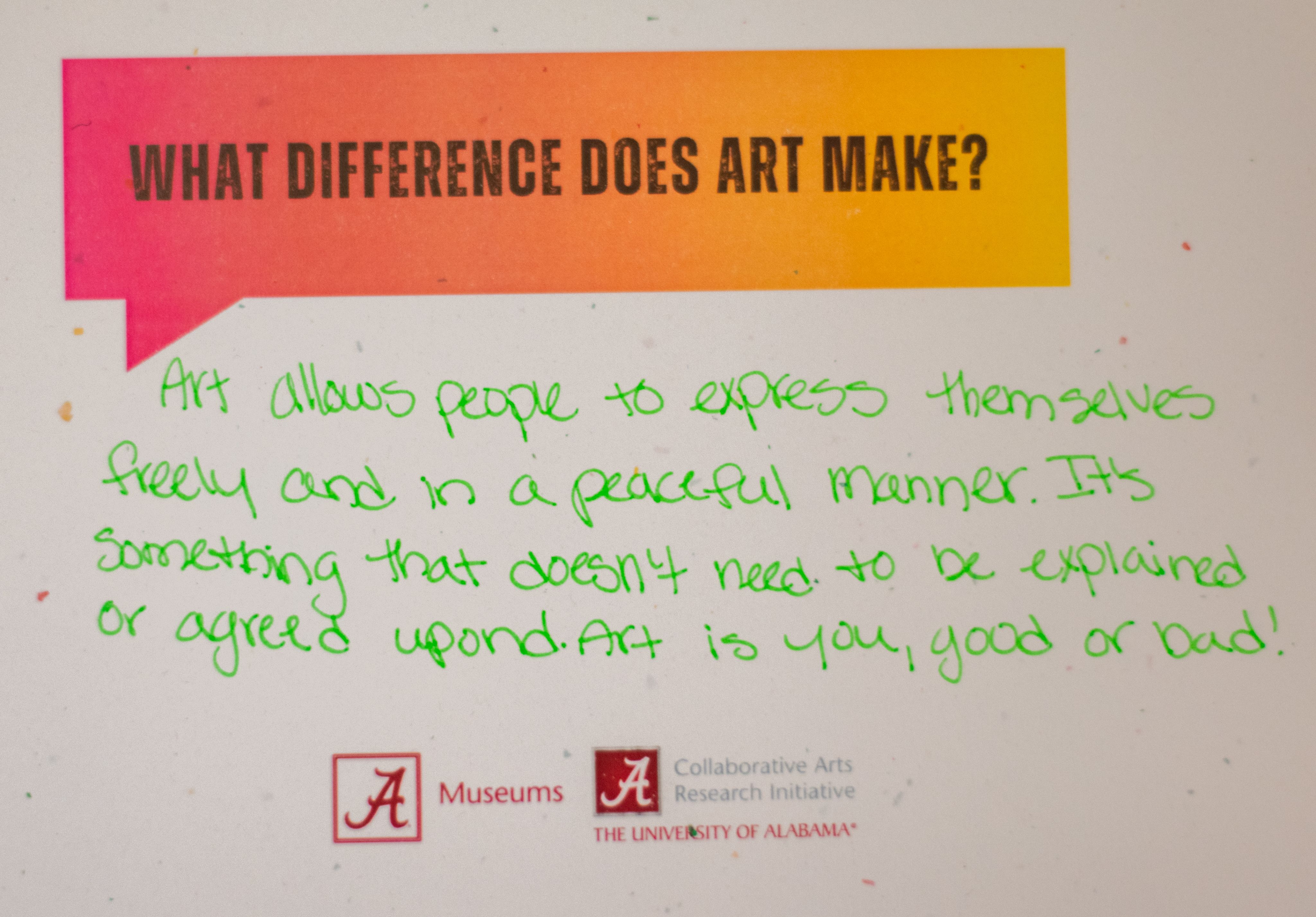 A colorful graphic featuring the question "What difference does art make?" followed by a response, "Art allows people to express themselves freely and in a peaceful manner. It's something that doesn't need to be explained or agreed upon. Art is you, good or bad!" Logos for the Collaborative Arts Research Initiative, and The University of Alabama Museums are displayed at the bottom.