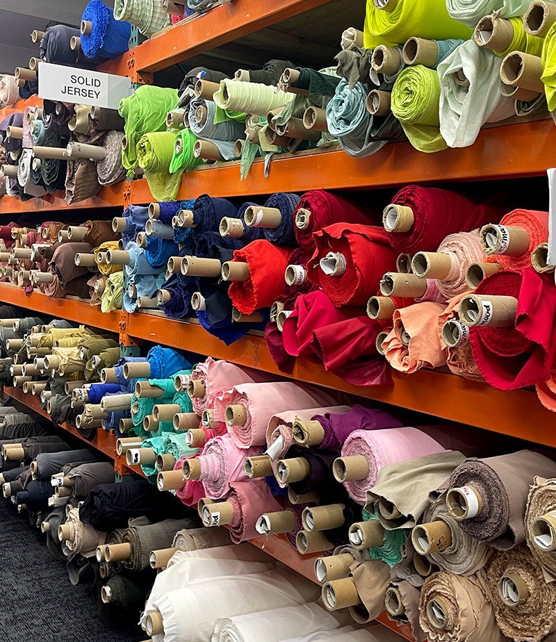 Cloth displayed on racks in a vietnamese fabric store.