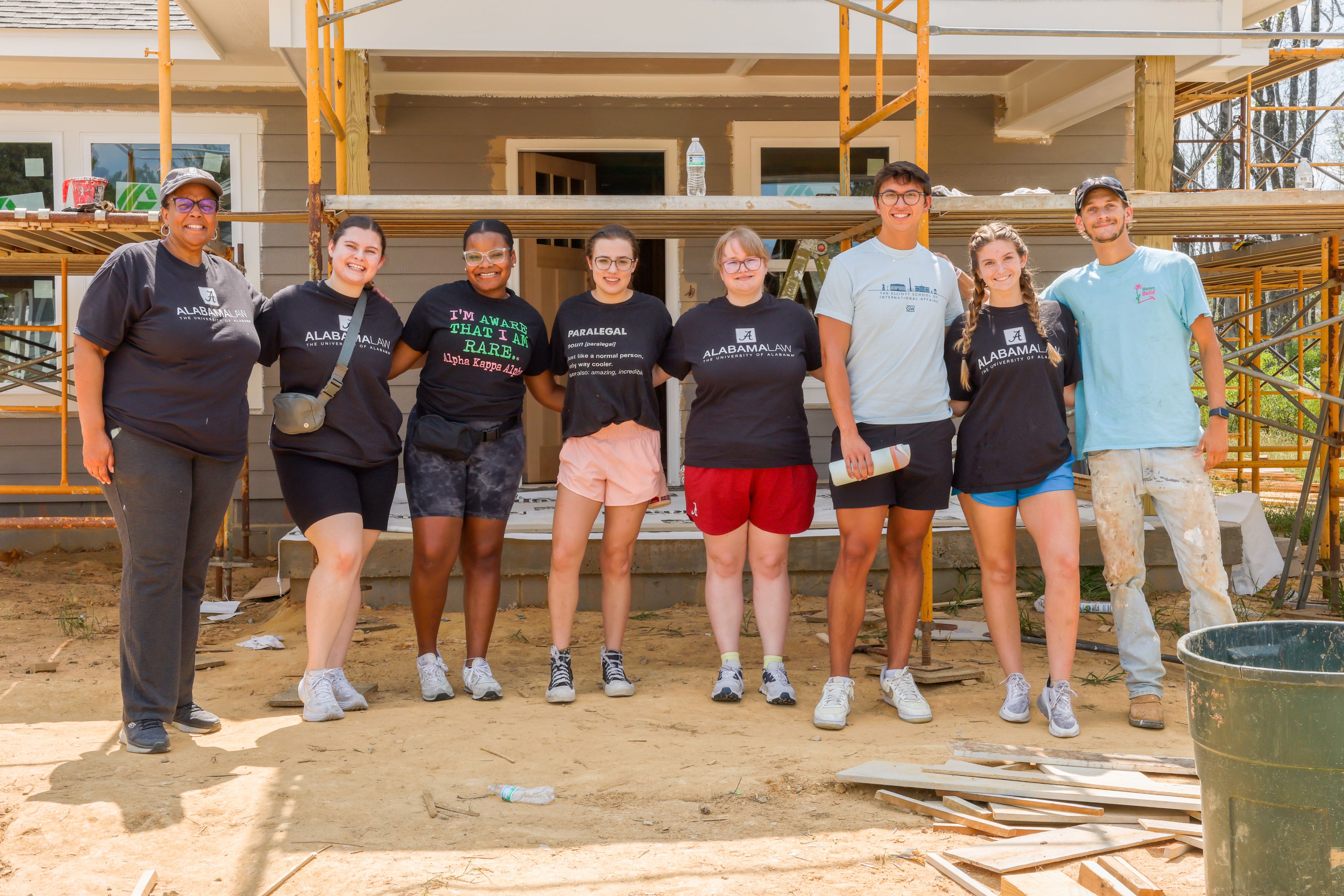 A group of eight people on a Habitat for Humanity job site.