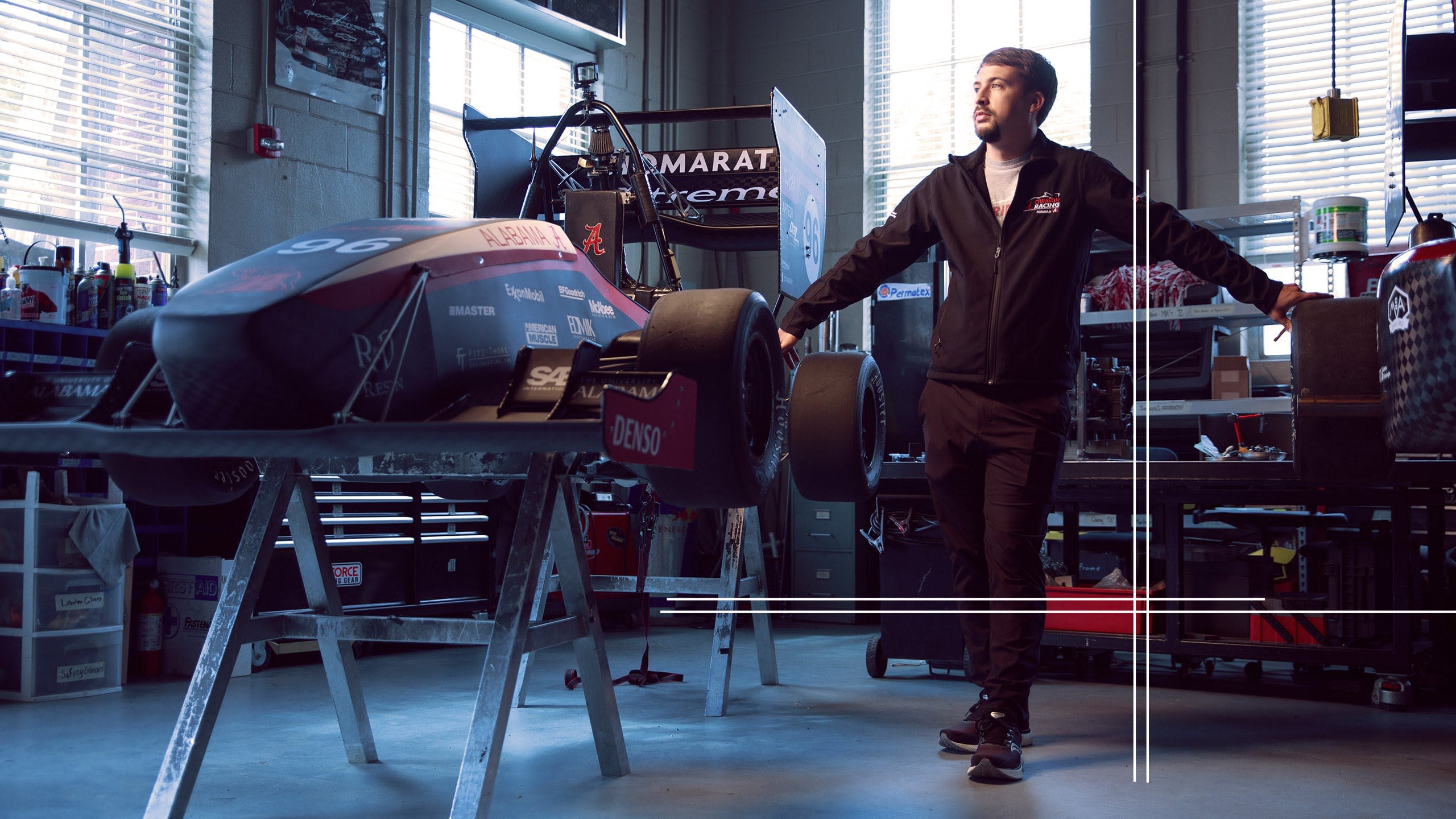 Cole Frederick stands beside the UA Racing competition car.