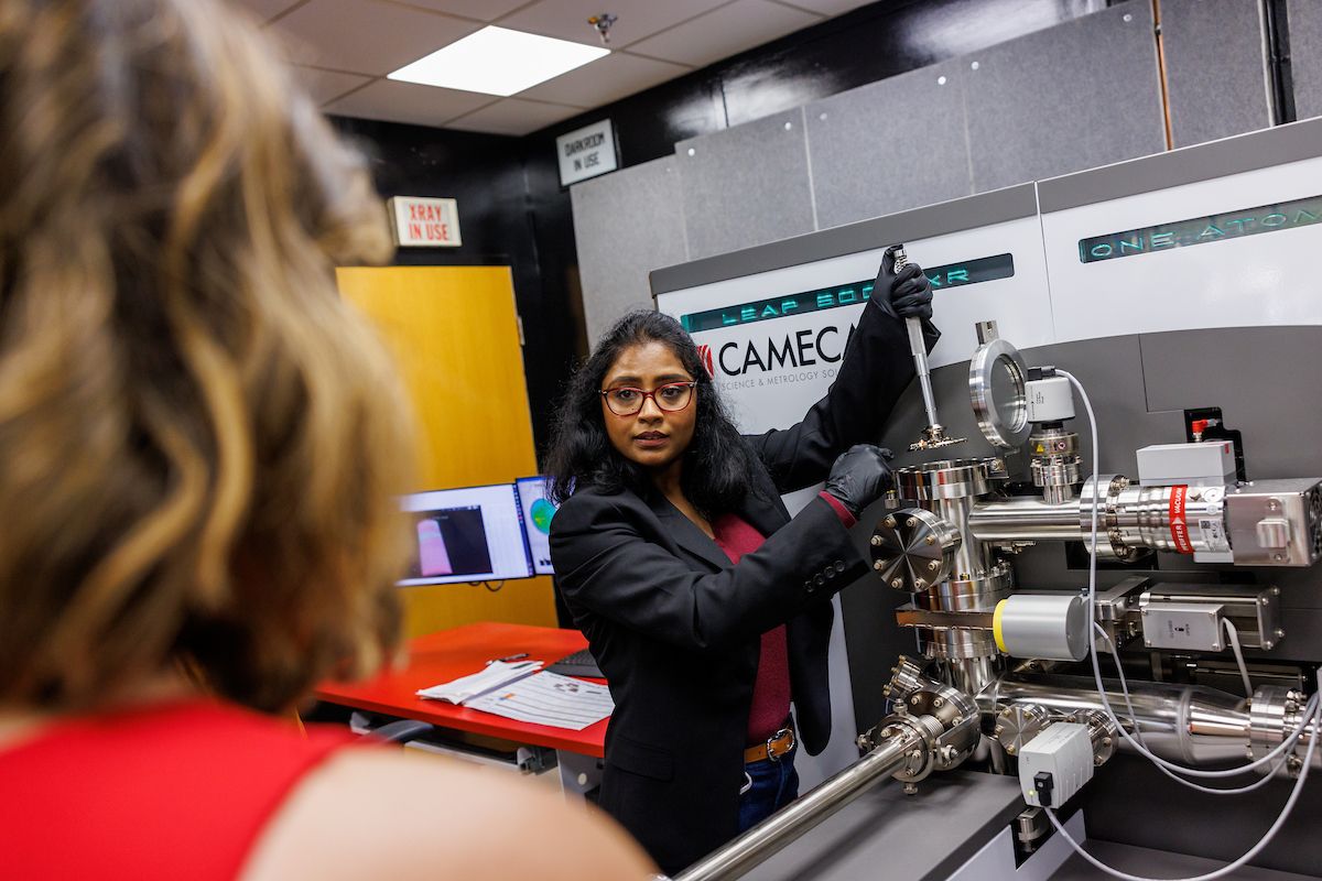 two graduate students examining a piece of lab equipment