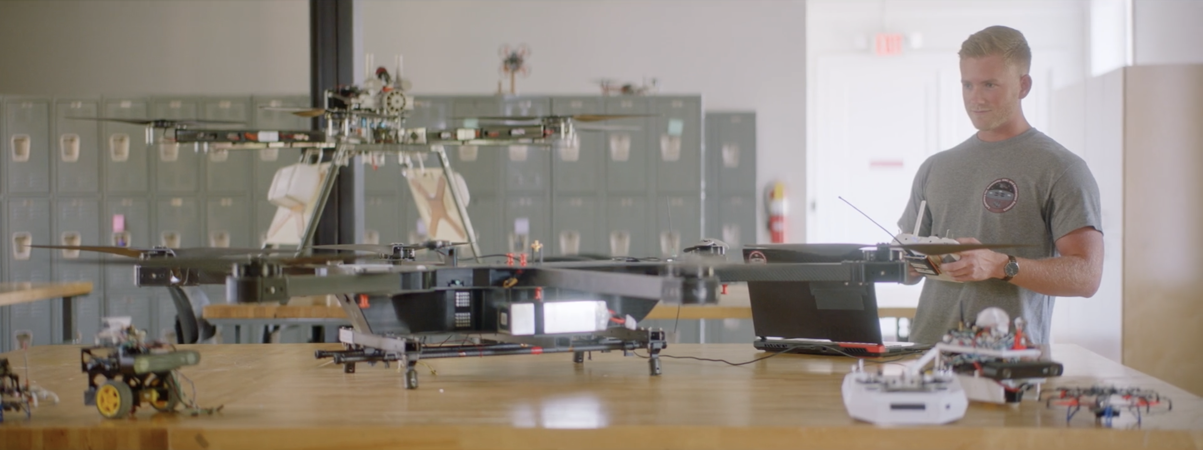 Zac works with drone equipment at a workbench.