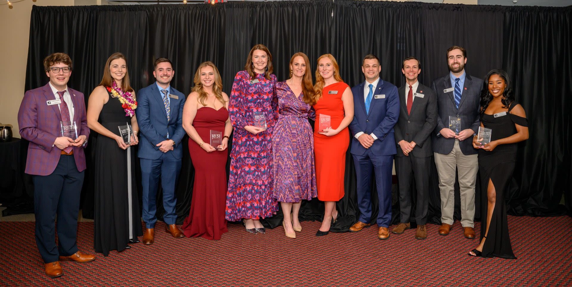 A group photo of Dean Sippial and the 18 under 31 awards recipients who are Honors College graduates